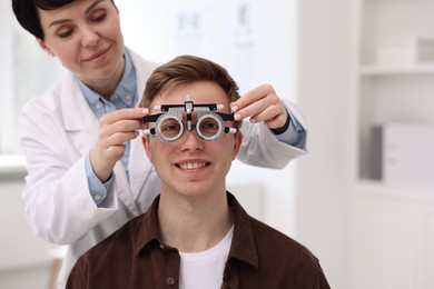Photo of Ophthalmologist examining patient's vision with trial frame in clinic