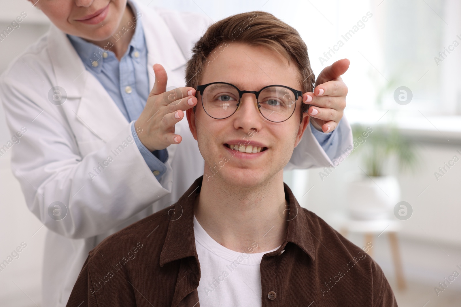 Ophthalmologist giving glasses to patient in clinic, closeup Photo of Ophthalmologist giving glasses to patient in clinic, closeup
