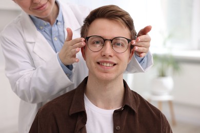 Photo of Ophthalmologist giving glasses to patient in clinic, closeup