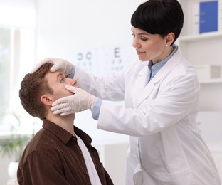 Photo of Professional ophthalmologist examining patient's vision in clinic