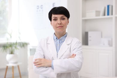 Photo of Portrait of professional ophthalmologist with crossed arms in clinic