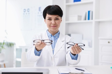 Photo of Portrait of professional ophthalmologist at white table in clinic