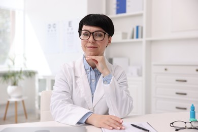 Photo of Portrait of professional ophthalmologist at white table in clinic