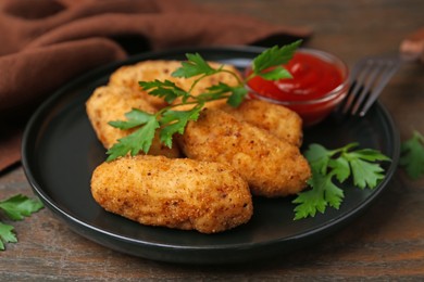 Photo of Tasty fried croquettes, parsley and sauce on wooden table, closeup