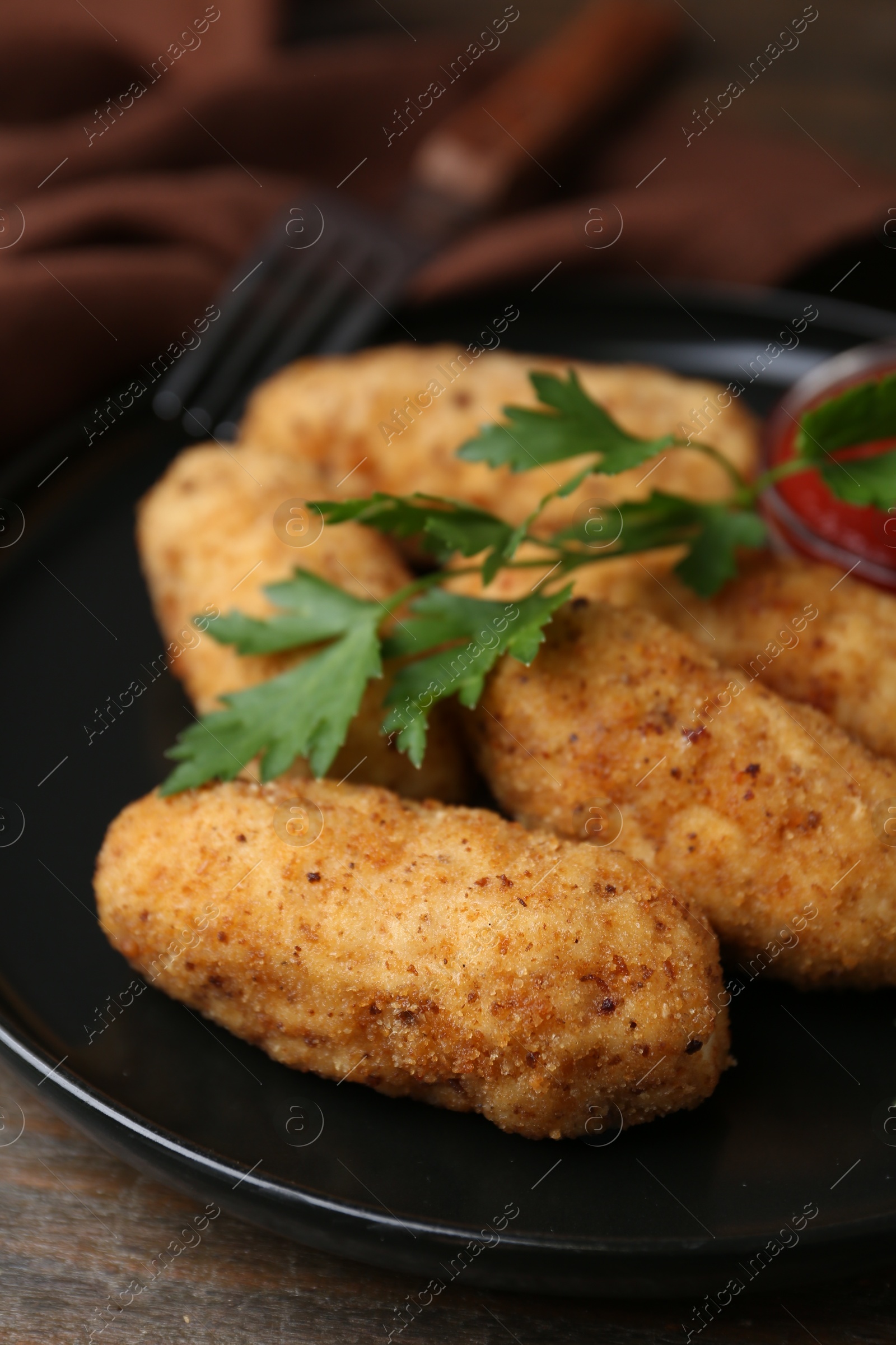 Tasty fried croquettes, parsley and sauce on wooden table, closeup Photo of Tasty fried croquettes, parsley and sauce on wooden table, closeup
