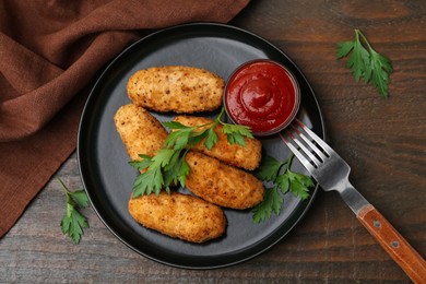 Photo of Tasty fried croquettes, parsley and sauce on wooden table, flat lay