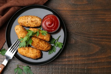 Photo of Tasty fried croquettes, parsley and sauce on wooden table, flat lay. Space for text