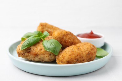 Photo of Tasty fried croquettes, basil and sauce on white tiled table, closeup