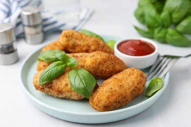 Photo of Tasty fried croquettes, basil and sauce on white tiled table, closeup