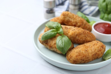Photo of Tasty fried croquettes, basil and sauce on white tiled table, closeup. Space for text