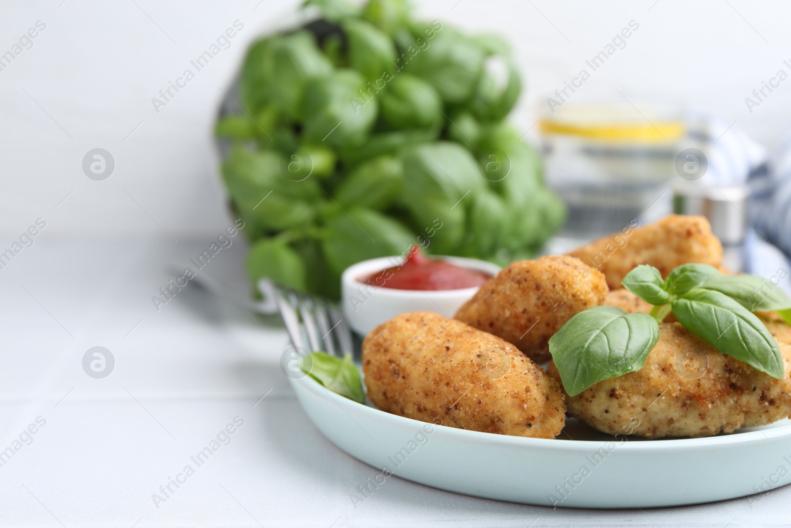 Tasty fried croquettes, basil and sauce on white tiled table, closeup. Space for text Photo of Tasty fried croquettes, basil and sauce on white tiled table, closeup. Space for text