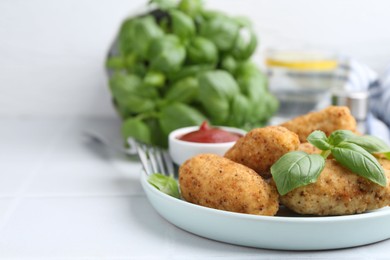 Photo of Tasty fried croquettes, basil and sauce on white tiled table, closeup. Space for text