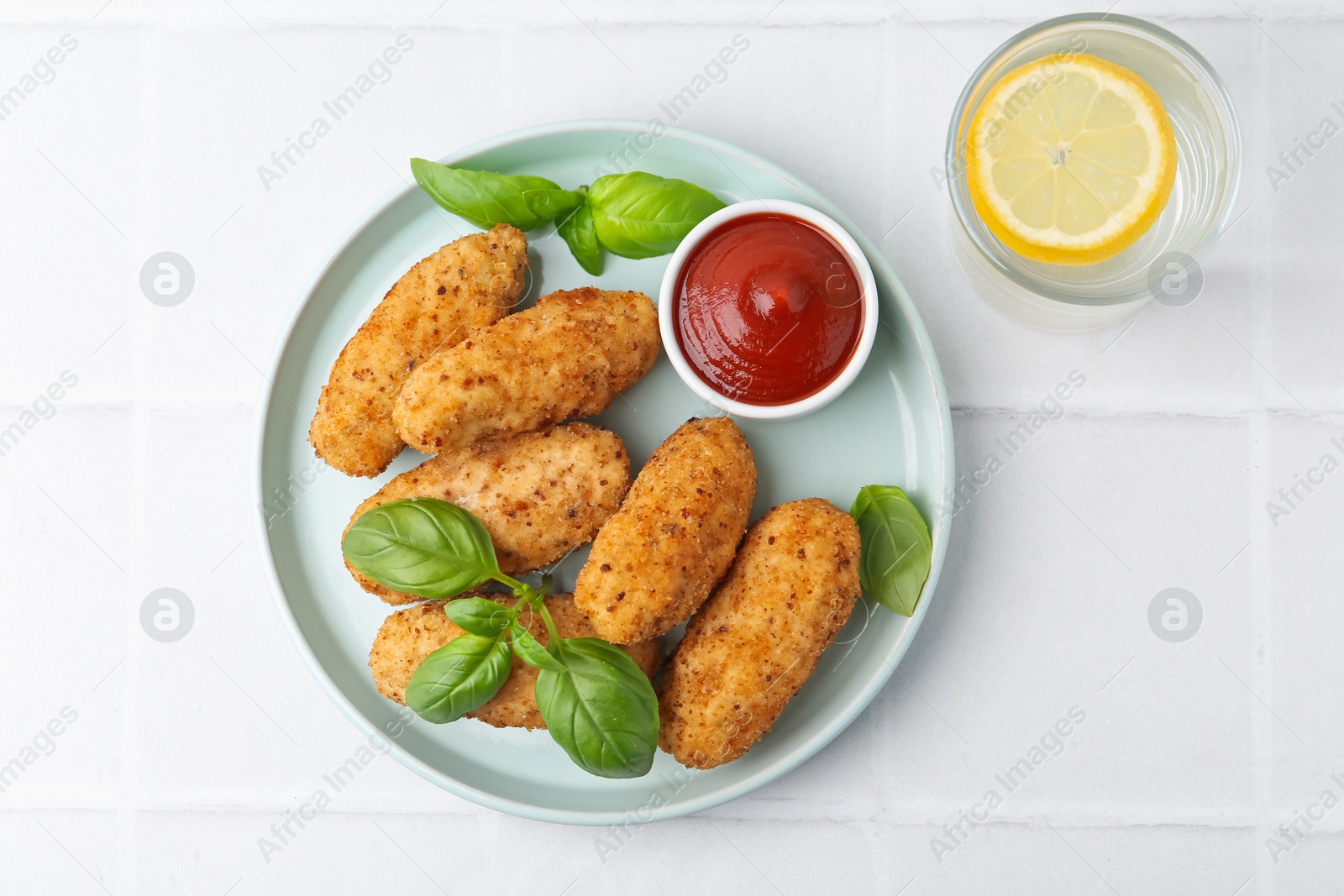 Tasty fried croquettes, basil and sauce served on white tiled table, top view Photo of Tasty fried croquettes, basil and sauce served on white tiled table, top view