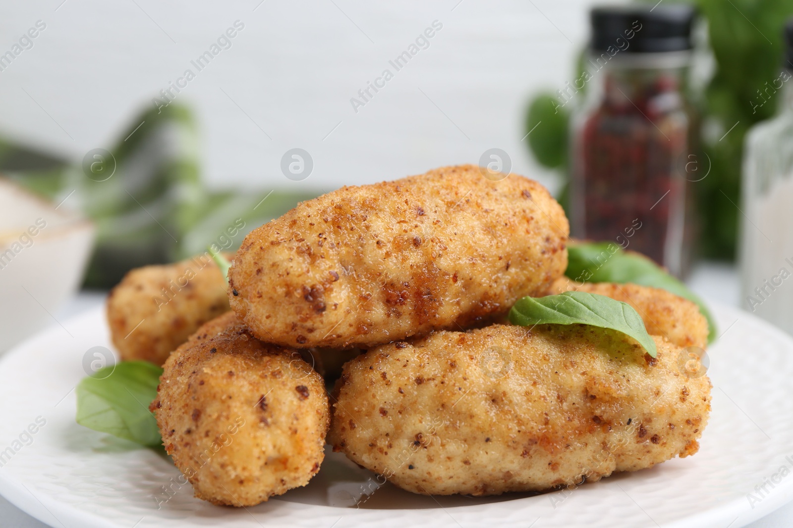 Tasty fried croquettes and basil on table, closeup Photo of Tasty fried croquettes and basil on table, closeup