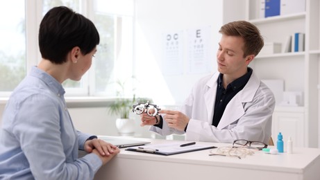Photo of Ophthalmologist consulting woman at table in clinic