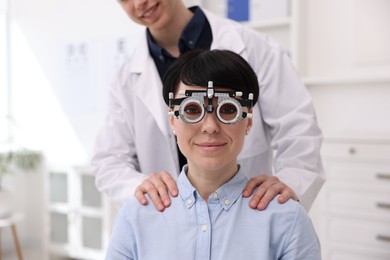 Photo of Ophthalmologist examining patient's vision with trial frame in clinic