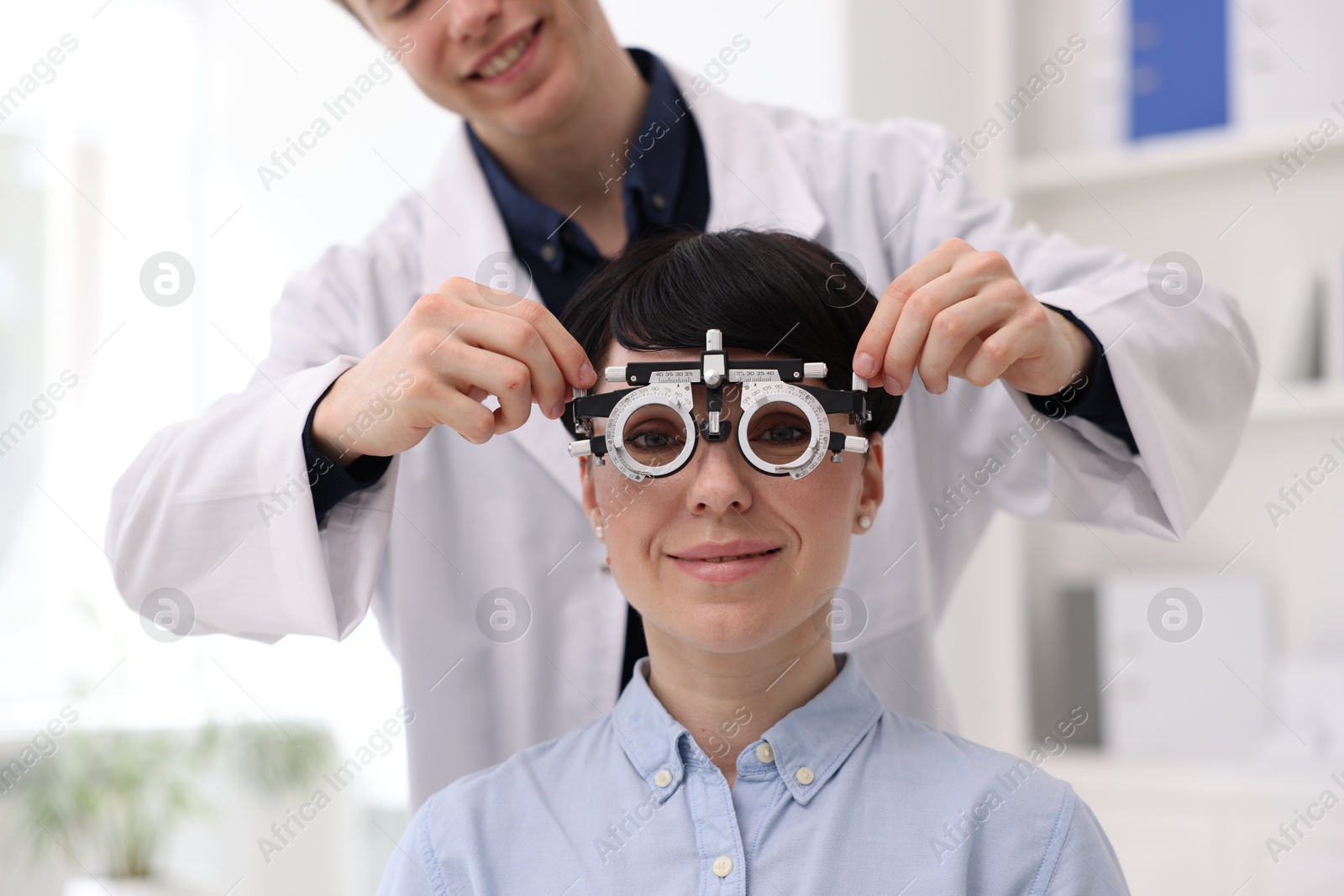 Ophthalmologist examining patient's vision with trial frame in clinic, closeup Photo of Ophthalmologist examining patient's vision with trial frame in clinic, closeup