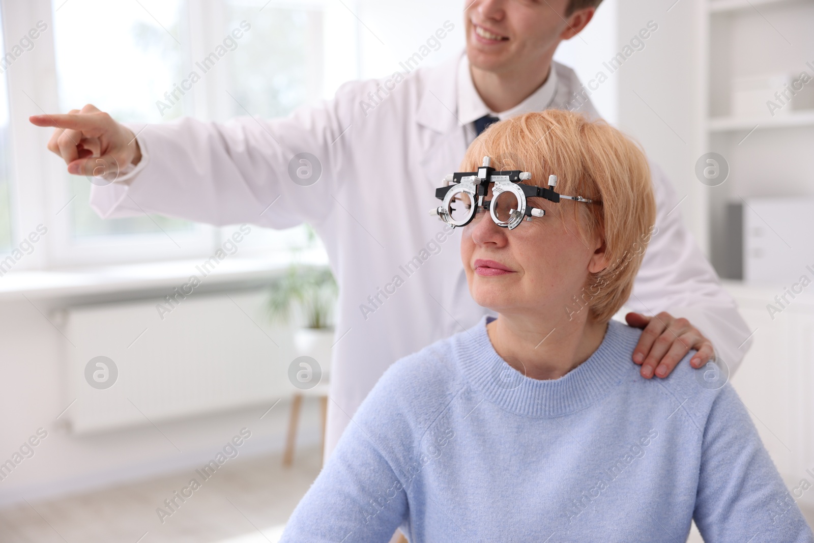 Ophthalmologist examining patient's vision with trial frame in clinic Photo of Ophthalmologist examining patient's vision with trial frame in clinic