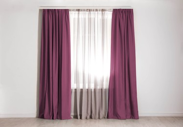 Image of Window with red purple curtains in room. Interior design