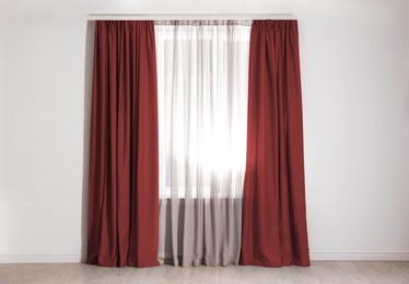 Image of Window with dark red curtains in room. Interior design