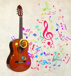 Image of Acoustic guitar and colorful music notes on beige background
