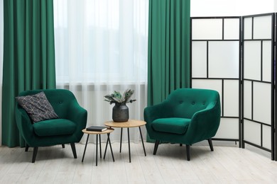 Image of Living room with green armchairs and curtains. Interior design