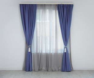 Image of Window with blue curtains in room. Interior design