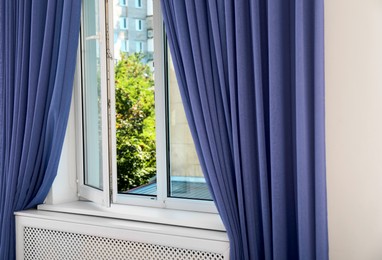 Image of Window with violet blue curtains in room. Interior design