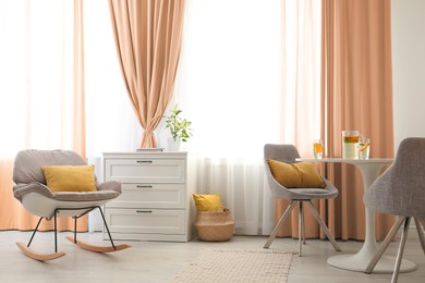 Image of Different furniture and peach color curtains in room. Interior design
