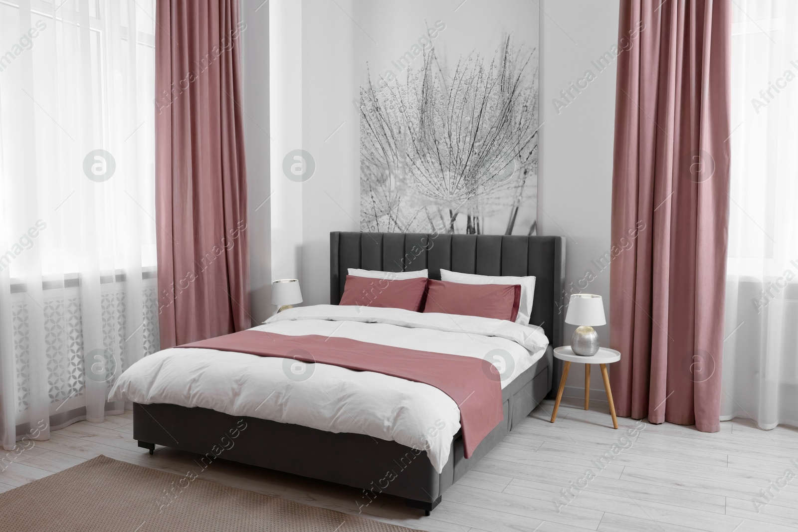 Bed between windows with dusty pink curtains in room. Interior design Image of Bed between windows with dusty pink curtains in room. Interior design