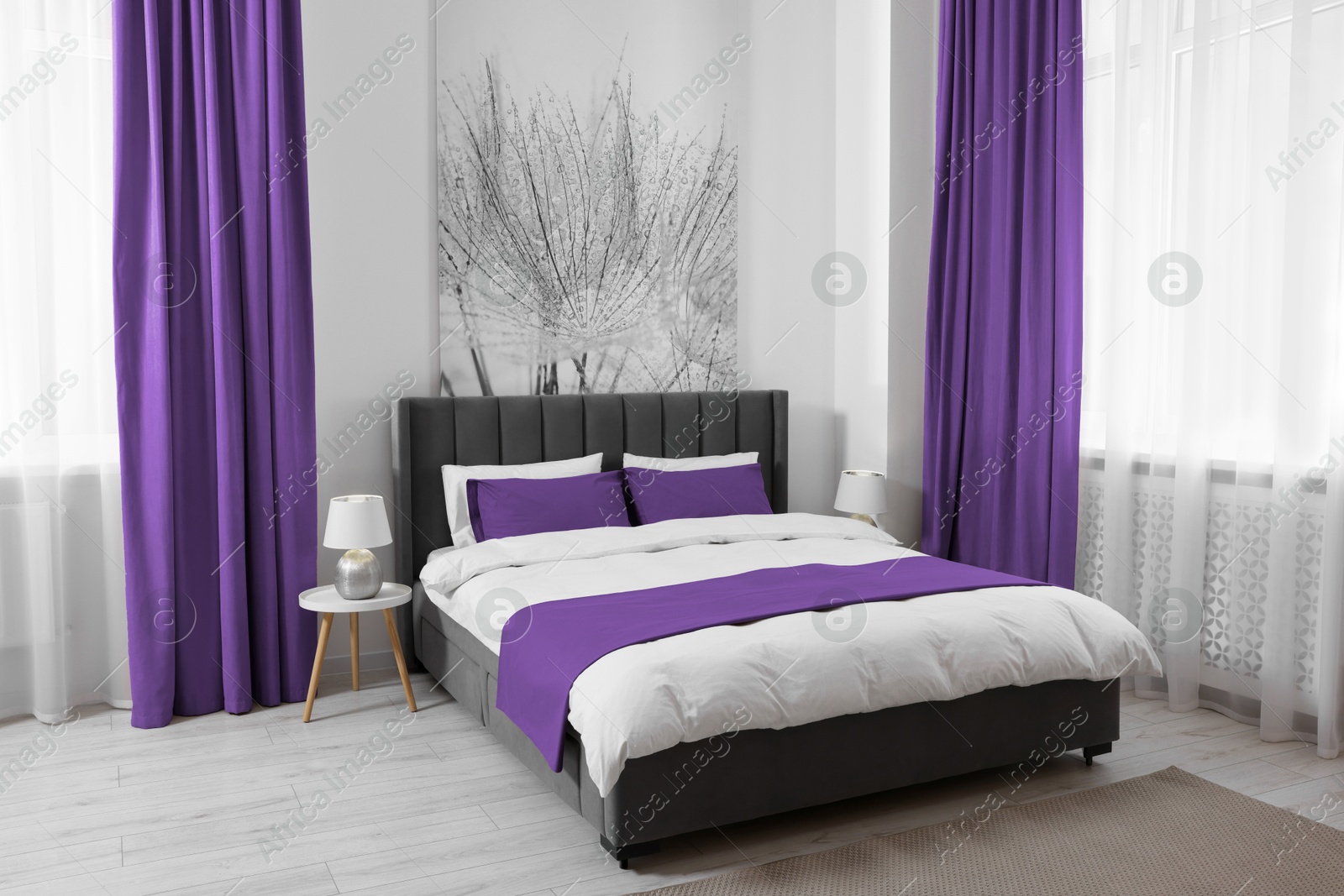 Bed between windows with purple curtains in room. Interior design Image of Bed between windows with purple curtains in room. Interior design