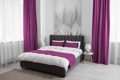 Image of Bed between windows with magenta curtains in room. Interior design