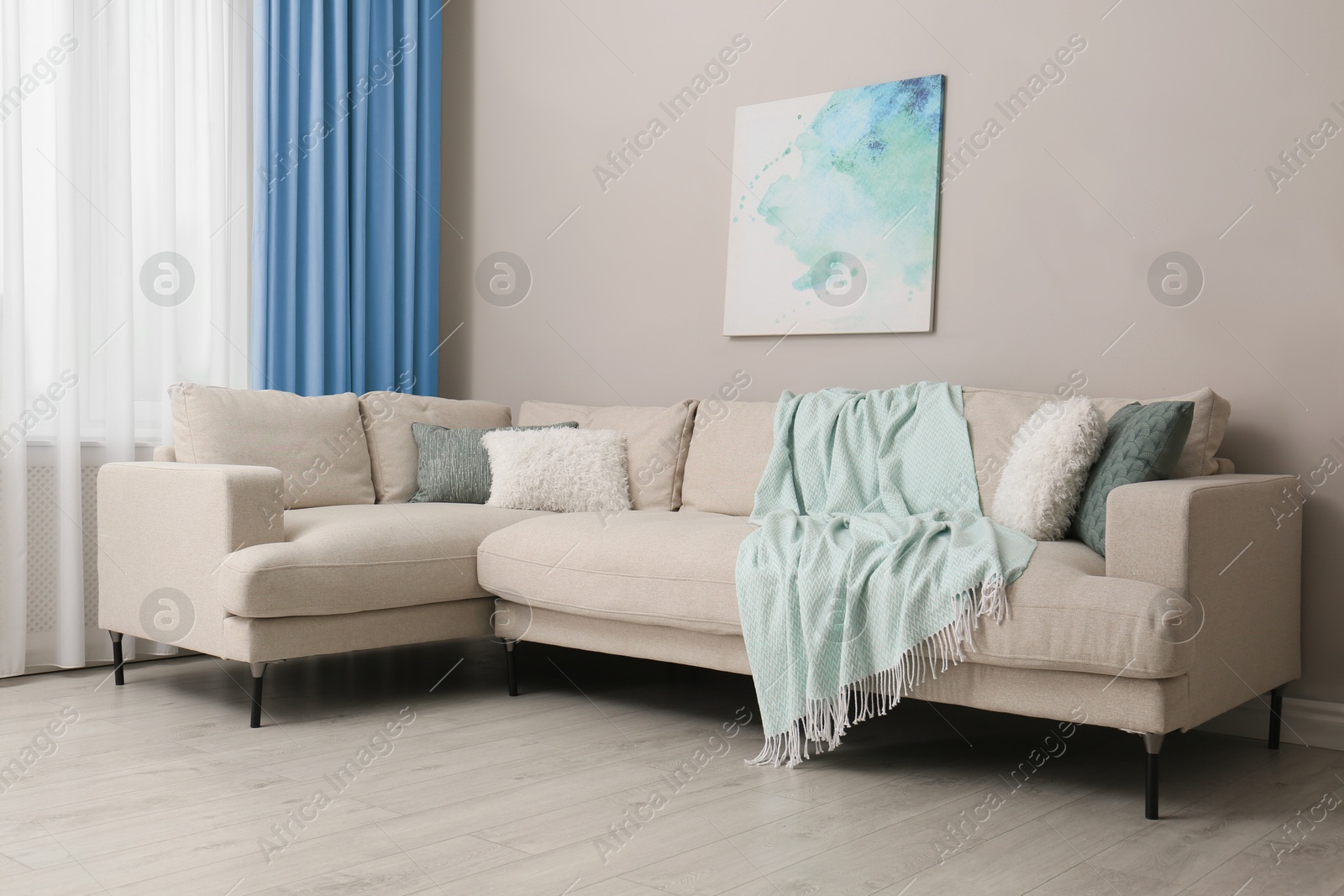 Comfortable sofa near window with light blue curtains in room. Interior design Image of Comfortable sofa near window with light blue curtains in room. Interior design