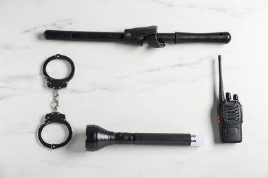 Photo of Different police equipment on white marble table, flat lay. Space for text
