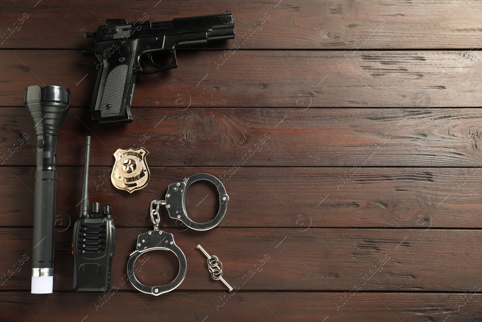 Photo of Different police equipment on wooden table, flat lay. Space for text