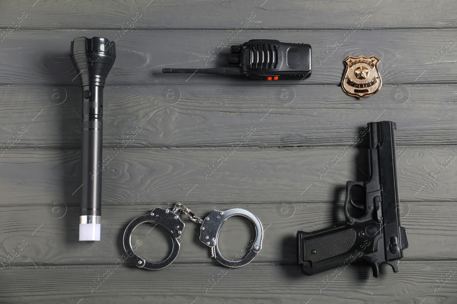 Photo of Different police equipment on grey wooden table, flat lay. Space for text