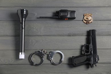 Photo of Different police equipment on grey wooden table, flat lay. Space for text
