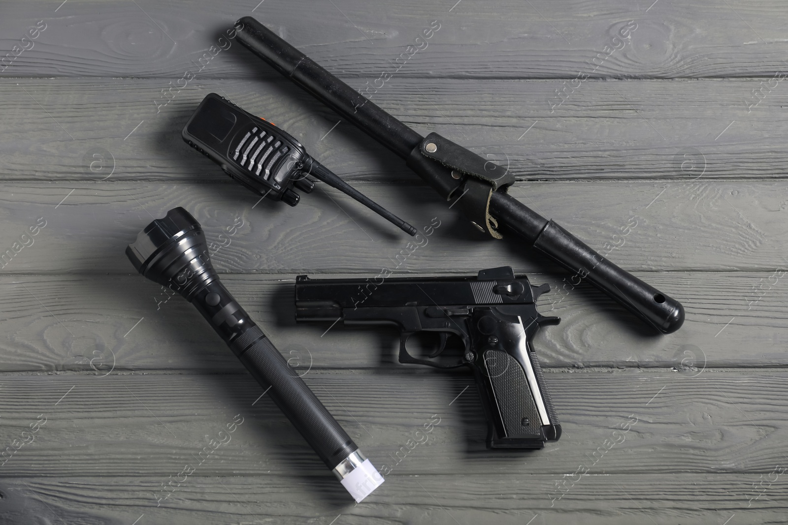 Photo of Different police equipment on grey wooden table, flat lay