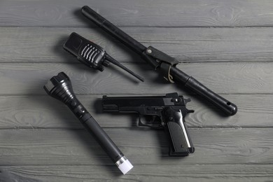 Photo of Different police equipment on grey wooden table, flat lay