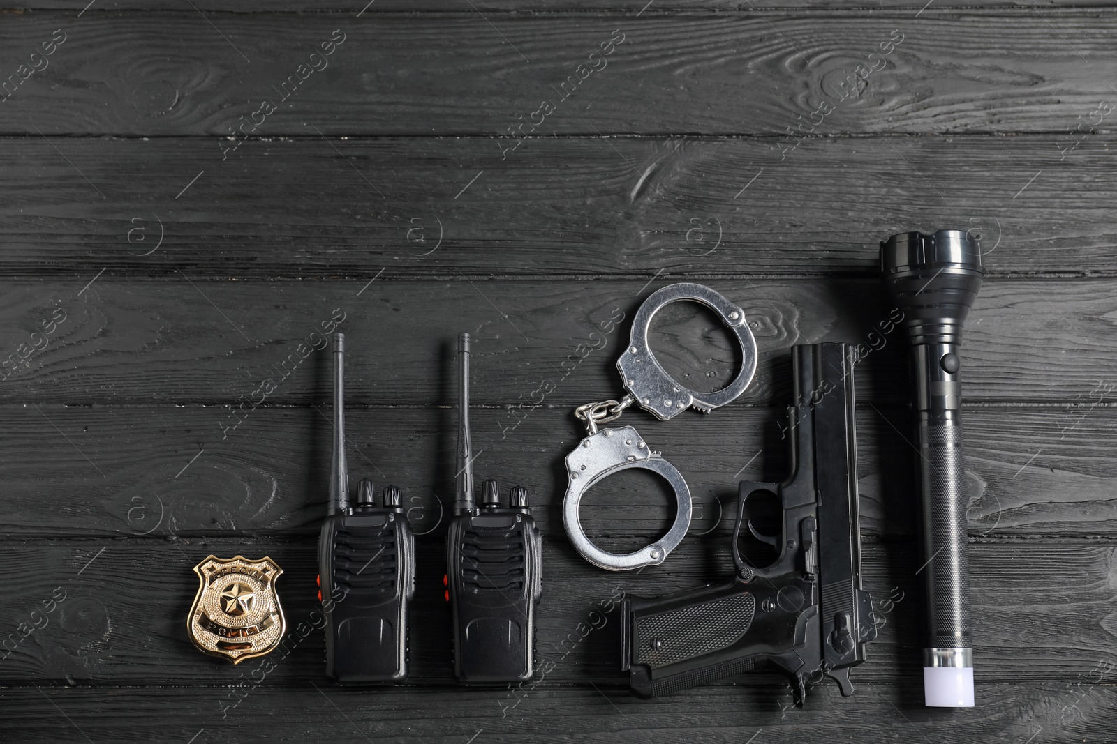 Different police equipment on black wooden table, flat lay Photo of Different police equipment on black wooden table, flat lay