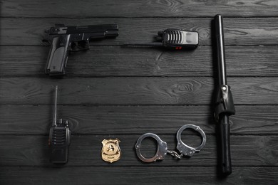 Photo of Different police equipment on black wooden table, flat lay. Space for text