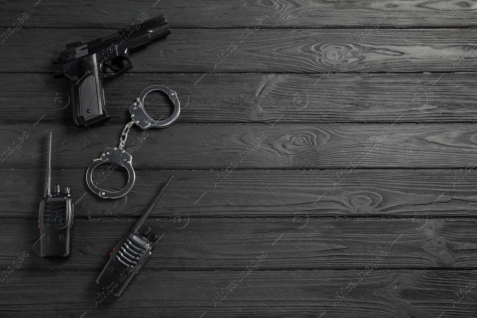 Photo of Different police equipment on black wooden table, flat lay. Space for text
