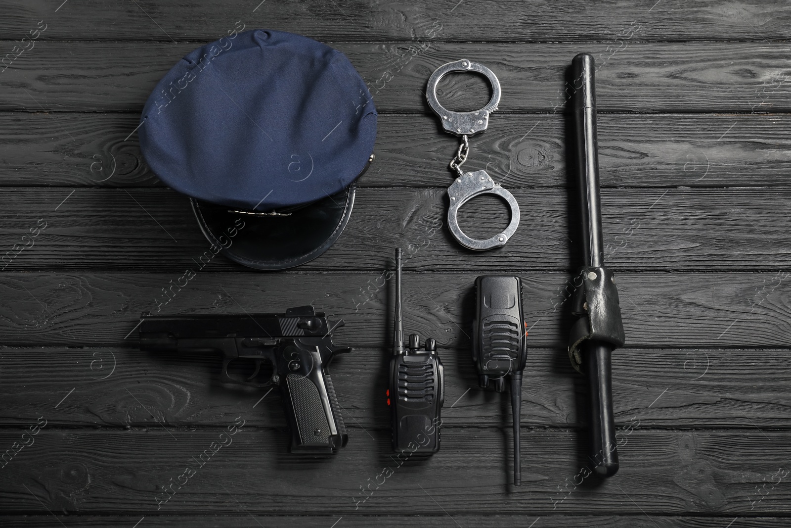 Different police equipment on black wooden table, flat lay Photo of Different police equipment on black wooden table, flat lay