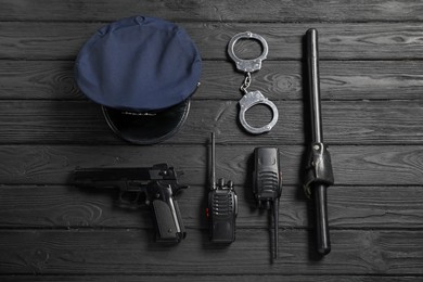Photo of Different police equipment on black wooden table, flat lay