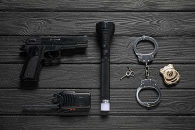 Photo of Different police equipment on black wooden table, flat lay