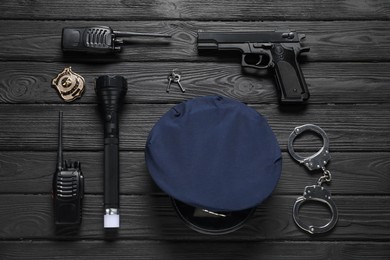 Photo of Different police equipment on black wooden table, flat lay