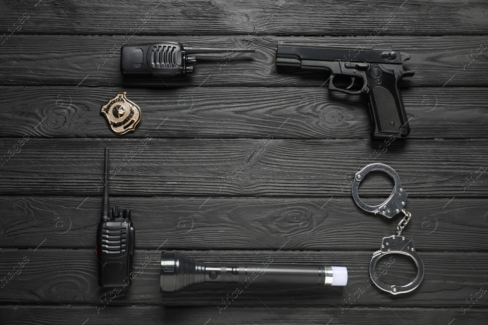 Photo of Different police equipment on black wooden table, flat lay. Space for text