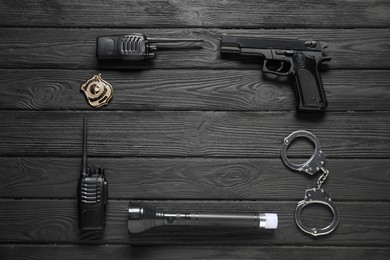 Photo of Different police equipment on black wooden table, flat lay. Space for text