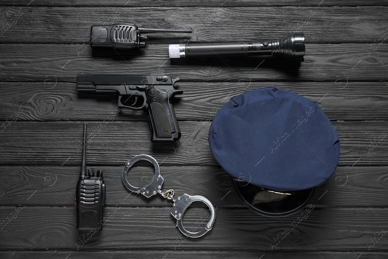 Different police equipment on black wooden table, flat lay Photo of Different police equipment on black wooden table, flat lay