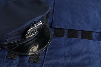 Photo of Police cap on dark blue uniform, closeup. Space for text